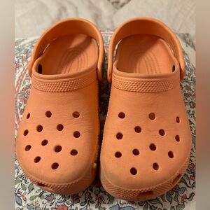 Pale orange Crocs.